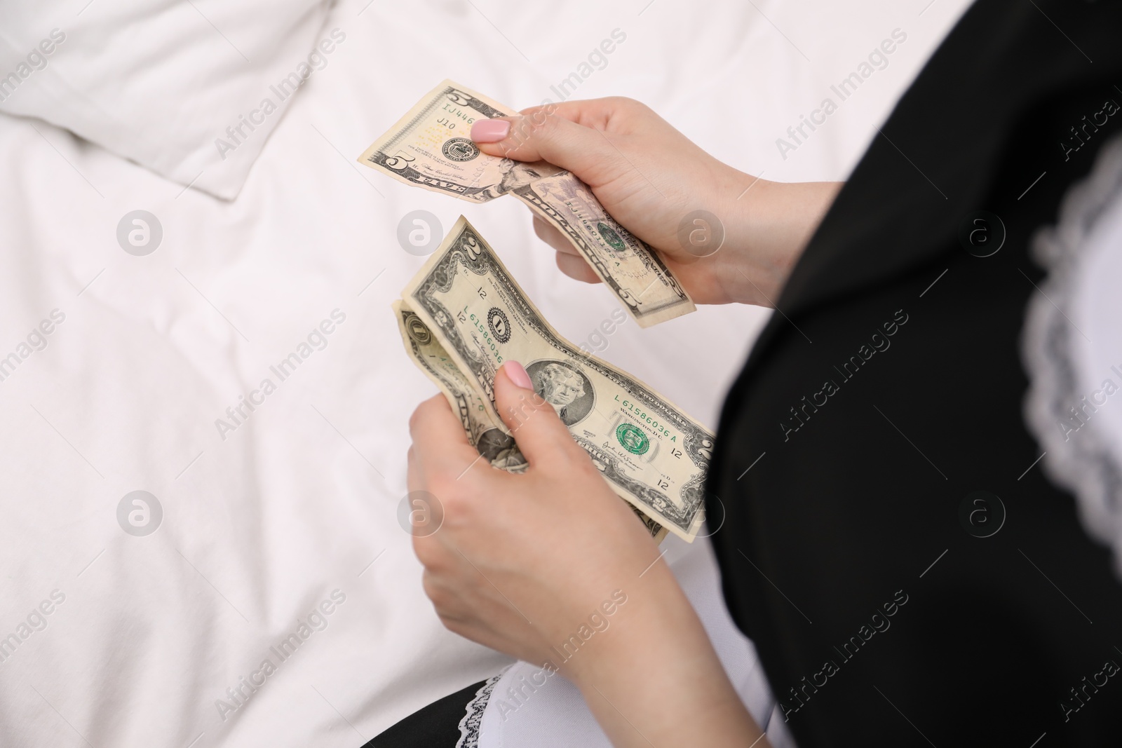 Chambermaid with tips on bed in hotel room, closeup. Gratuity for work Photo of Chambermaid with tips on bed in hotel room, closeup. Gratuity for work