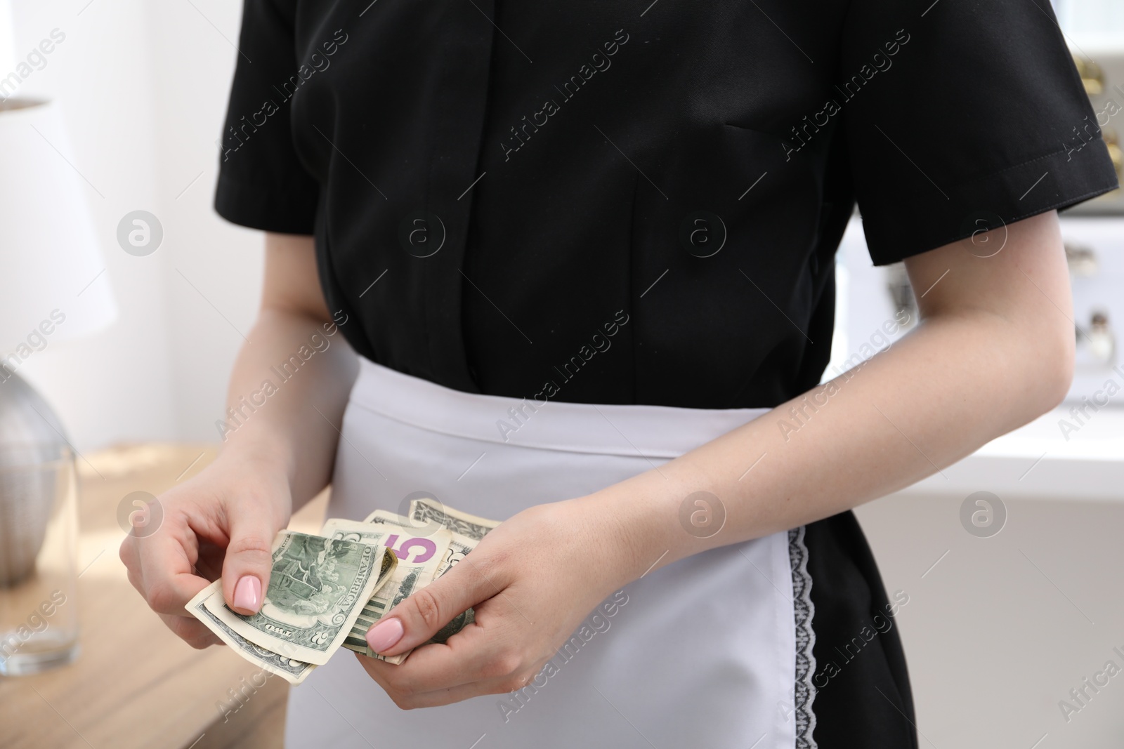 Chambermaid with tips in hotel room, closeup. Gratuity for work Photo of Chambermaid with tips in hotel room, closeup. Gratuity for work