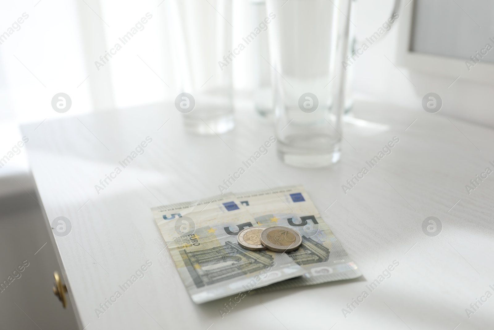 Tips on white wooden nightstand in hotel room, closeup. Gratuity for work Photo of Tips on white wooden nightstand in hotel room, closeup. Gratuity for work
