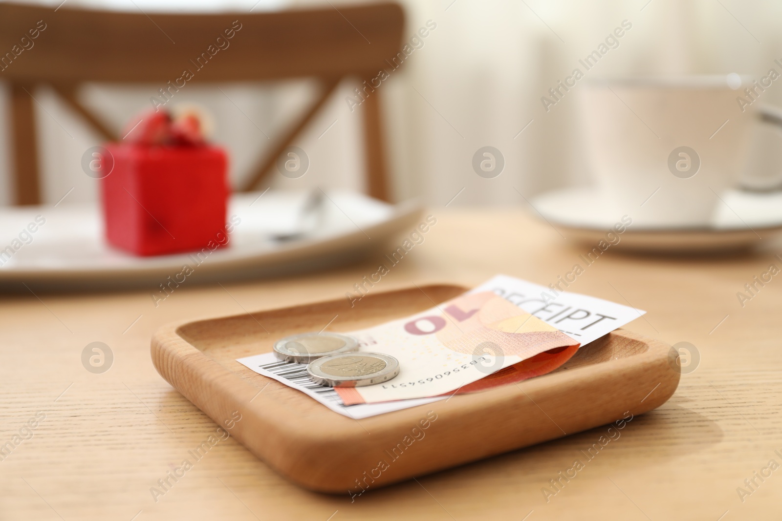 Tips and receipt on wooden table in restaurant, closeup. Gratuity for work Photo of Tips and receipt on wooden table in restaurant, closeup. Gratuity for work