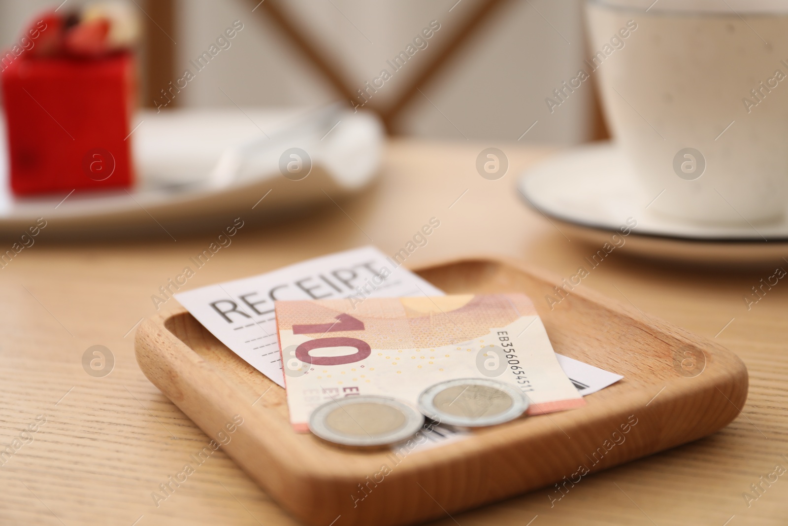 Tips and receipt on wooden table in restaurant, closeup. Gratuity for work Photo of Tips and receipt on wooden table in restaurant, closeup. Gratuity for work
