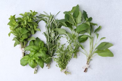 Photo of Different fresh green herbs on light table, flat lay