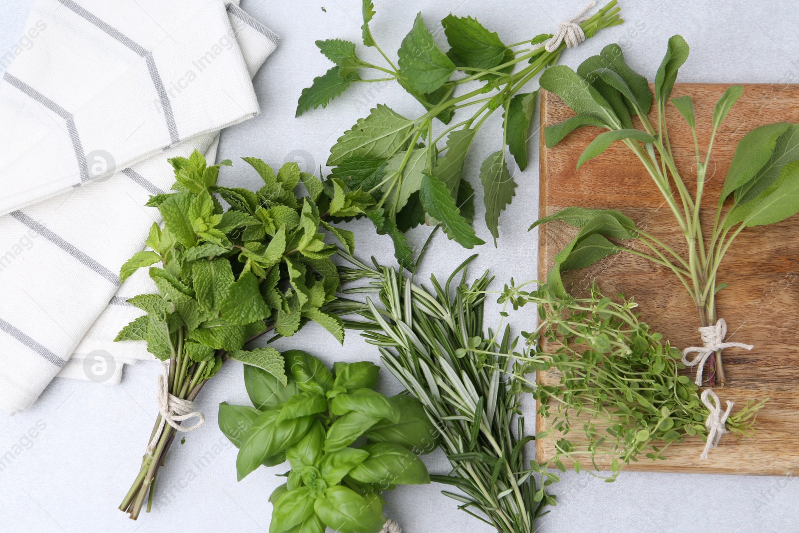 Photo of Different fresh green herbs on light table, flat lay