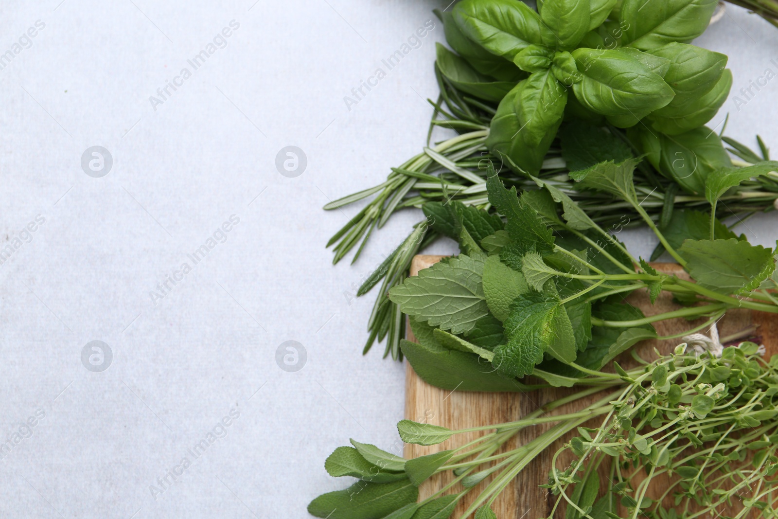 Photo of Different fresh green herbs on light table, flat lay. Space for text