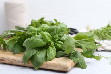 Photo of Different fresh green herbs on light table, closeup