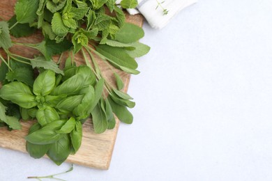 Photo of Different fresh green herbs on light table, top view. Space for text