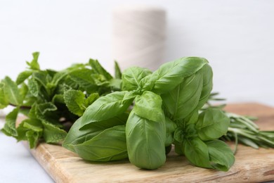 Photo of Different fresh green herbs on light table, closeup