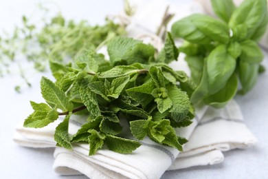 Photo of Different fresh green herbs on light table, closeup
