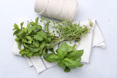 Photo of Different fresh green herbs and twine on light table, flat lay