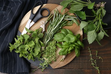Photo of Different fresh green herbs and scissors on wooden table, flat lay