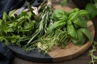 Photo of Different fresh green herbs on wooden table, closeup