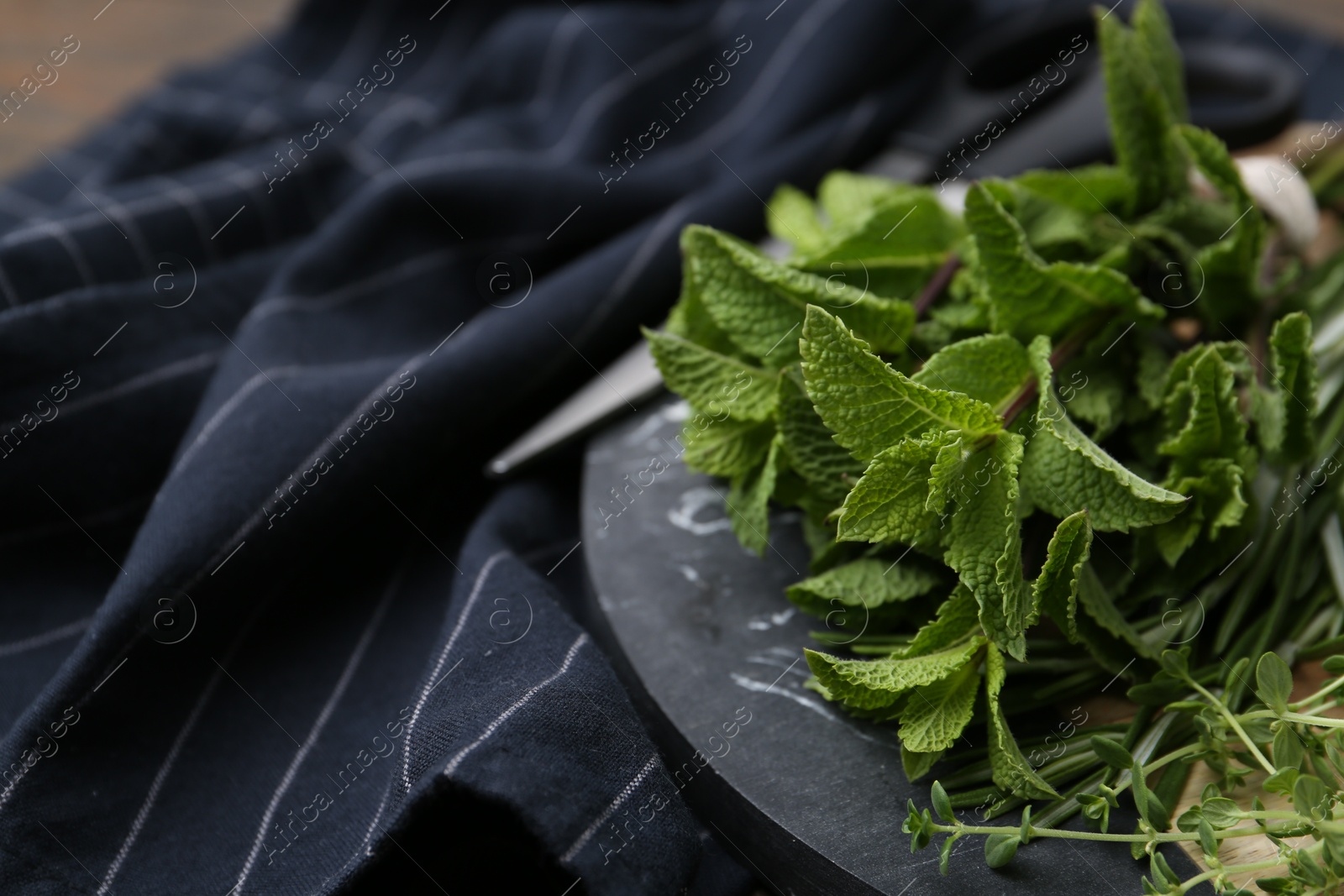 Different fresh green herbs and scissors on table, closeup. Space for text Photo of Different fresh green herbs and scissors on table, closeup. Space for text