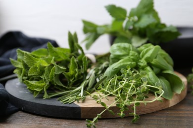 Photo of Different fresh green herbs on wooden table, closeup
