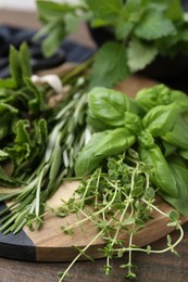 Photo of Different fresh green herbs on wooden table, closeup