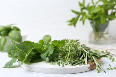 Photo of Different fresh green herbs on white table, closeup