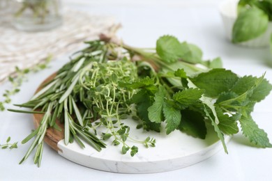 Photo of Different fresh green herbs on white table, closeup