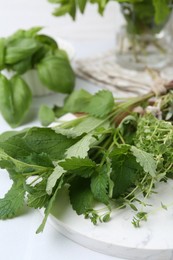 Photo of Different fresh green herbs on white table, closeup