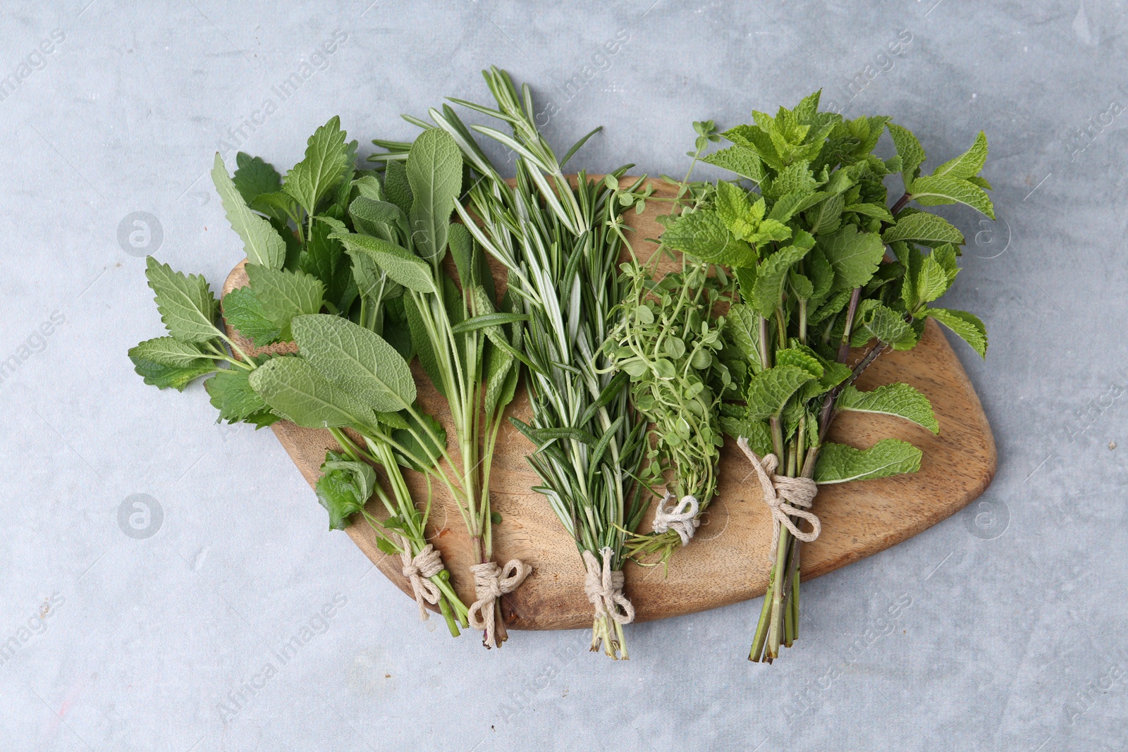 Different fresh green herbs on grey table, top view Photo of Different fresh green herbs on grey table, top view
