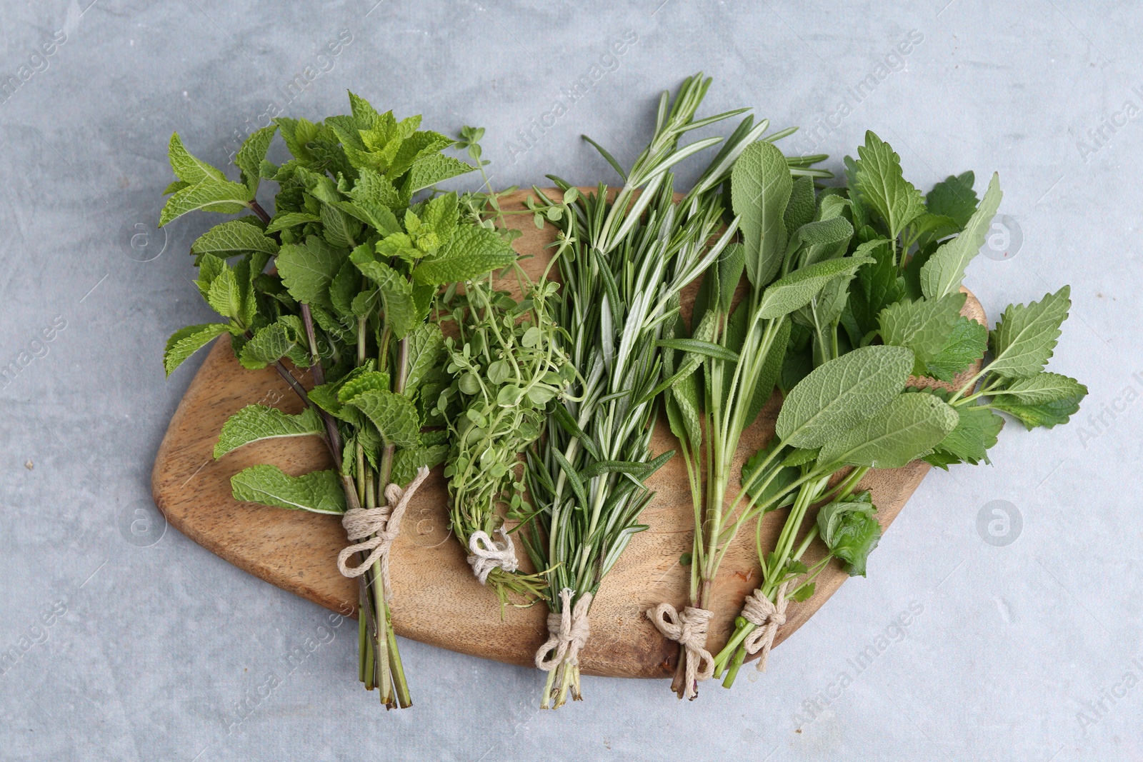 Different fresh green herbs on grey table, top view Photo of Different fresh green herbs on grey table, top view