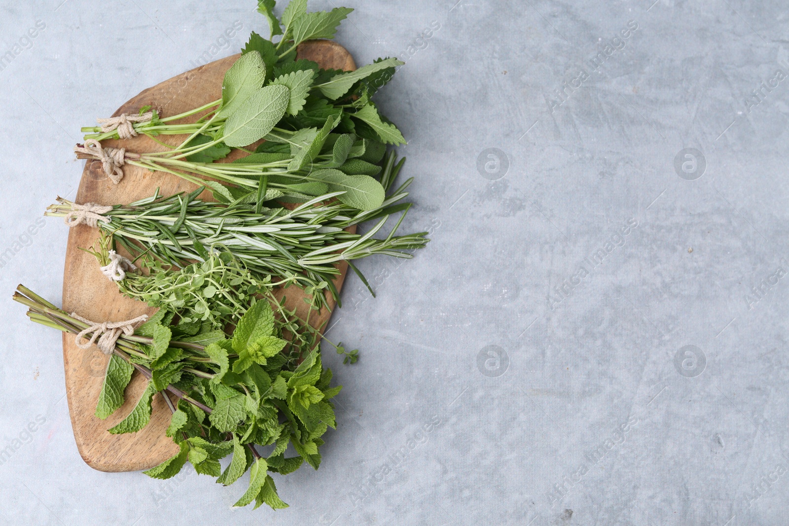 Photo of Different fresh green herbs on grey table, top view. Space for text