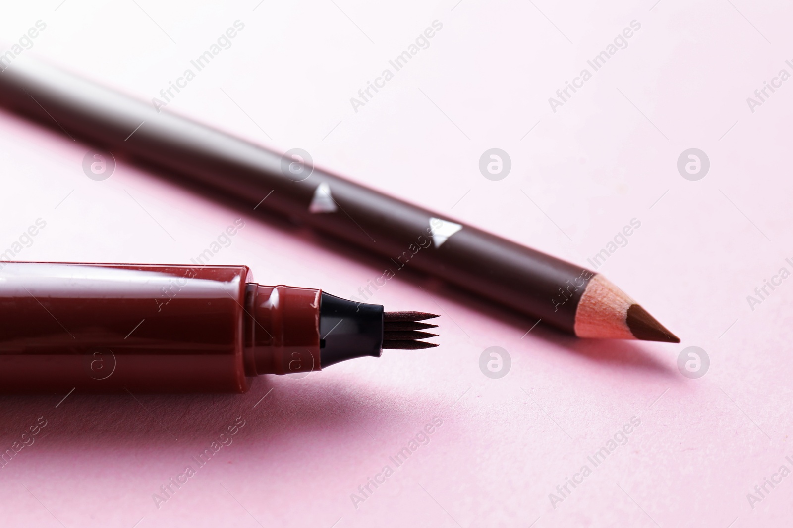 Different eyebrow pencils on pink background, closeup Photo of Different eyebrow pencils on pink background, closeup