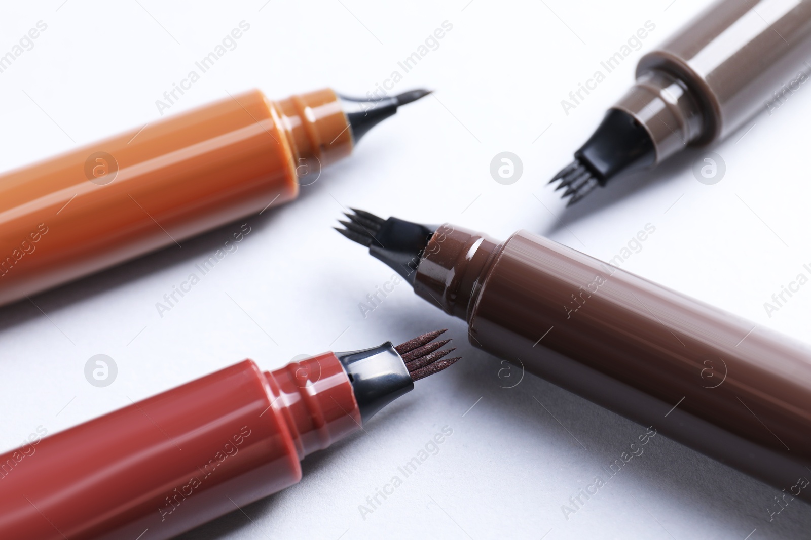 Liquid eyebrow pencils on white background, closeup Photo of Liquid eyebrow pencils on white background, closeup