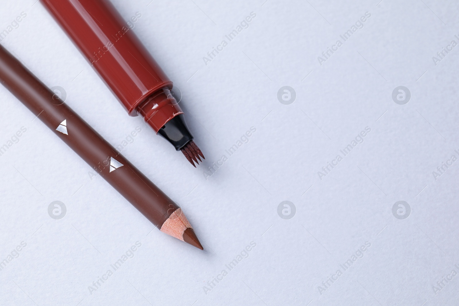 Different eyebrow pencils on white background, flat lay. Space for text Photo of Different eyebrow pencils on white background, flat lay. Space for text