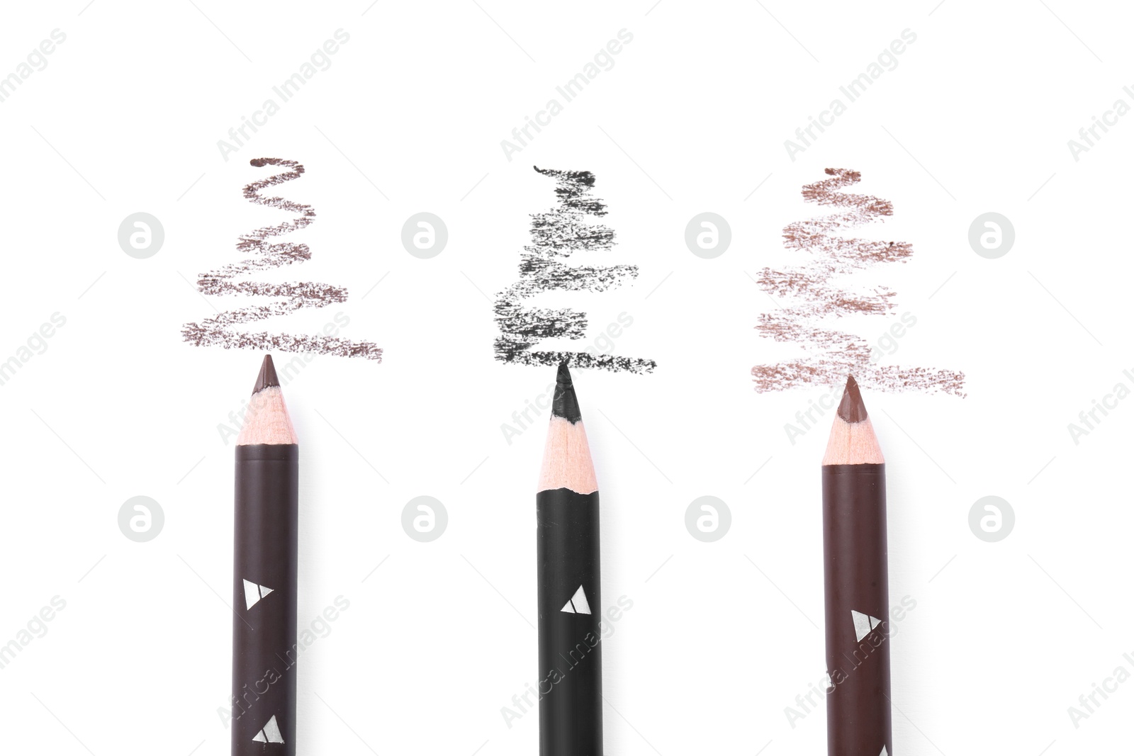 Different eyebrow pencils and strokes isolated on white, top view Photo of Different eyebrow pencils and strokes isolated on white, top view