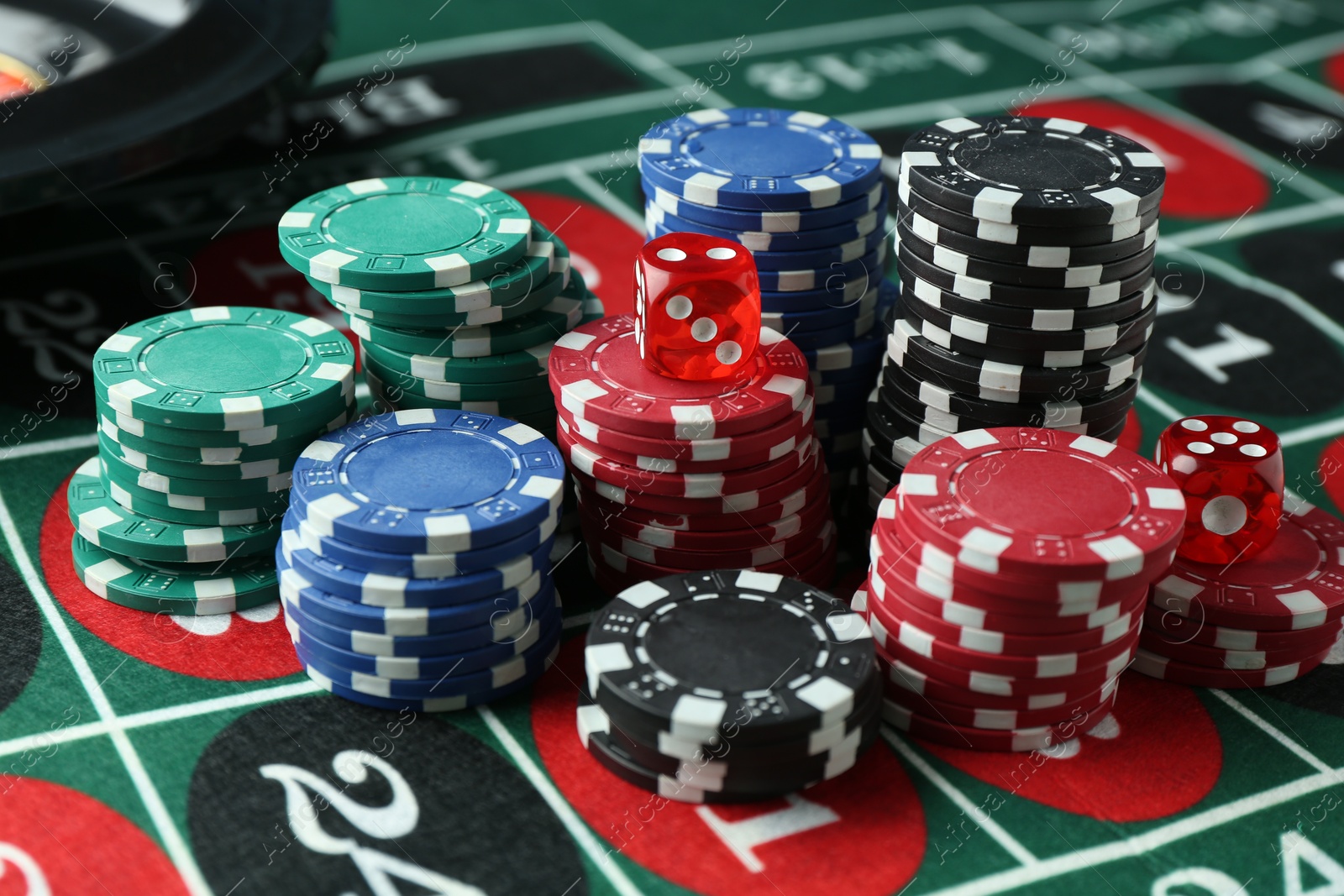 Casino chips and dice on roulette table, closeup Photo of Casino chips and dice on roulette table, closeup