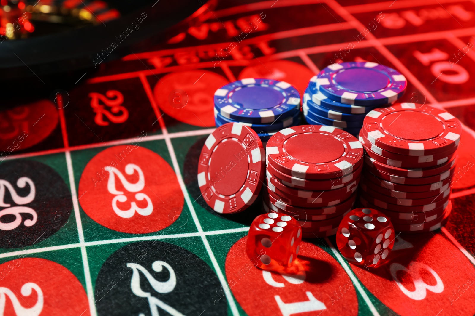 Casino chips and dice on roulette table, closeup Photo of Casino chips and dice on roulette table, closeup