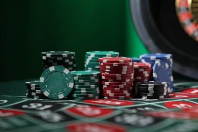 Photo of Casino chips on roulette table, closeup. Gambling addiction