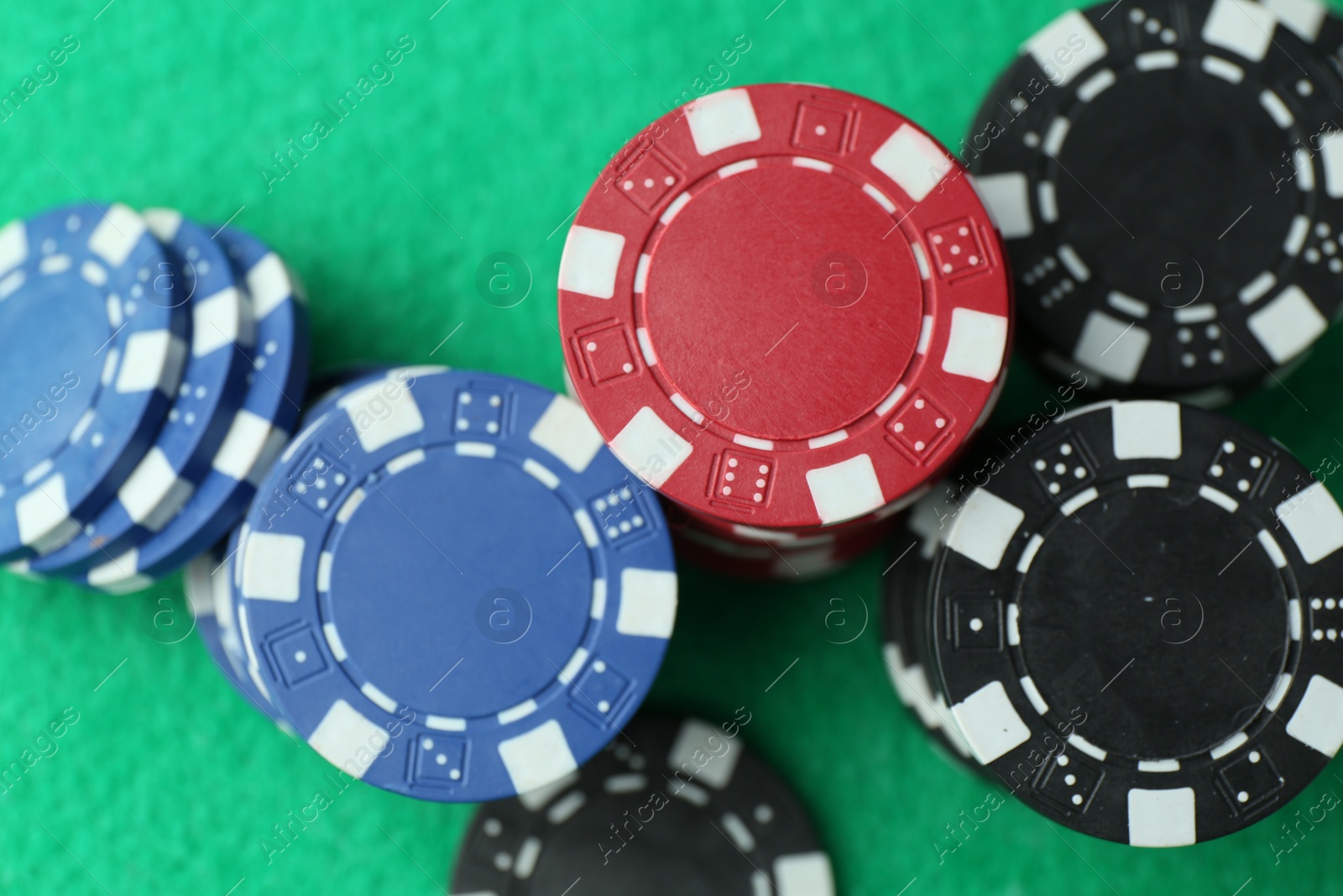Casino chips on green table, flat lay Photo of Casino chips on green table, flat lay