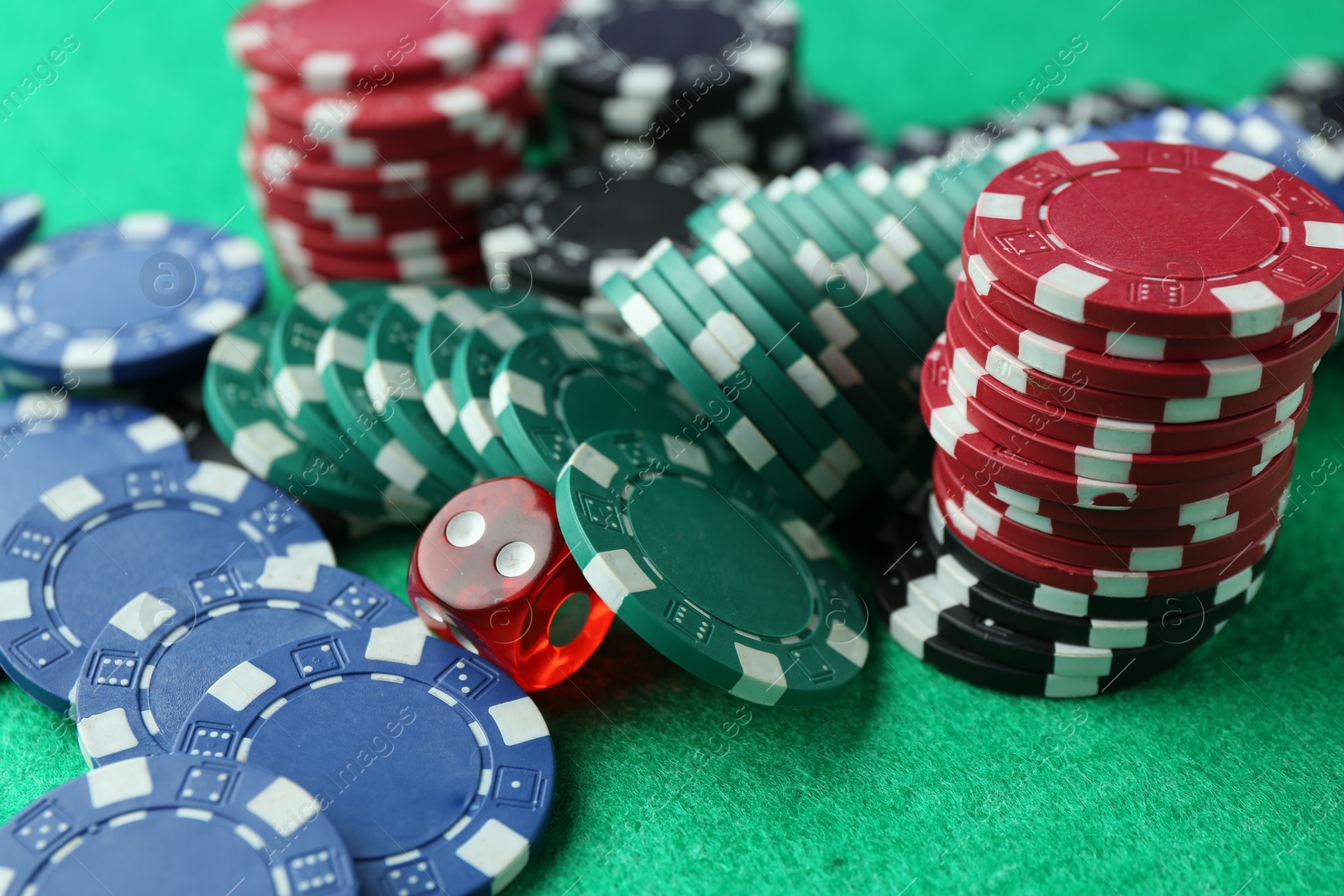 Casino chips and die on green table, closeup Photo of Casino chips and die on green table, closeup