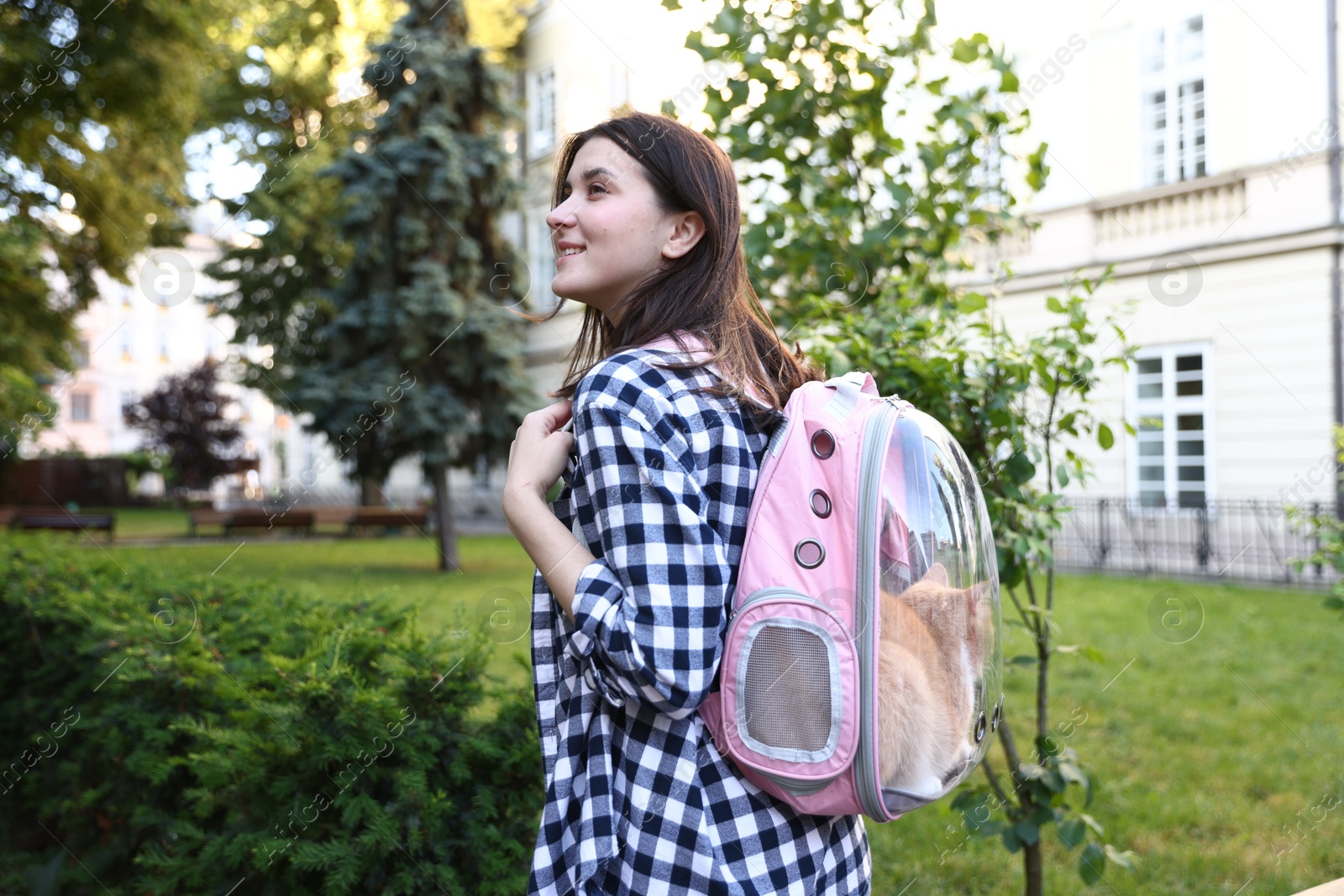 Woman with her cute cat in backpack carrier at park Photo of Woman with her cute cat in backpack carrier at park