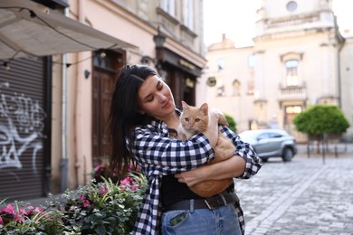 Photo of Woman with her cute cat outdoors on sunny day