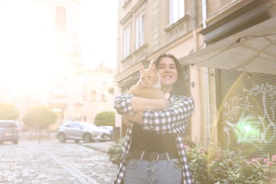 Photo of Woman with her cute cat outdoors on sunny day