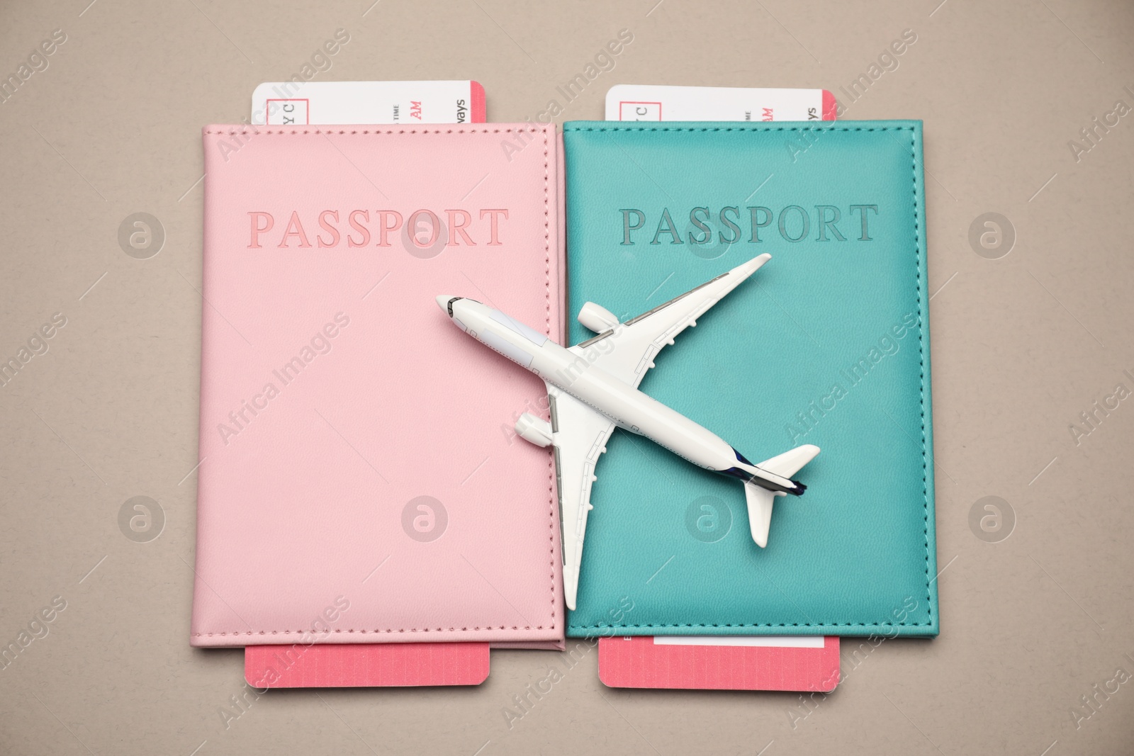Airplane model, passports and flight tickets on beige background, flat lay Photo of Airplane model, passports and flight tickets on beige background, flat lay