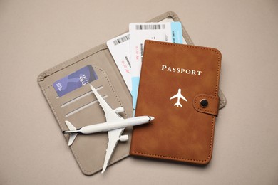Photo of Airplane model, passport, flight tickets and credit card on beige background, top view
