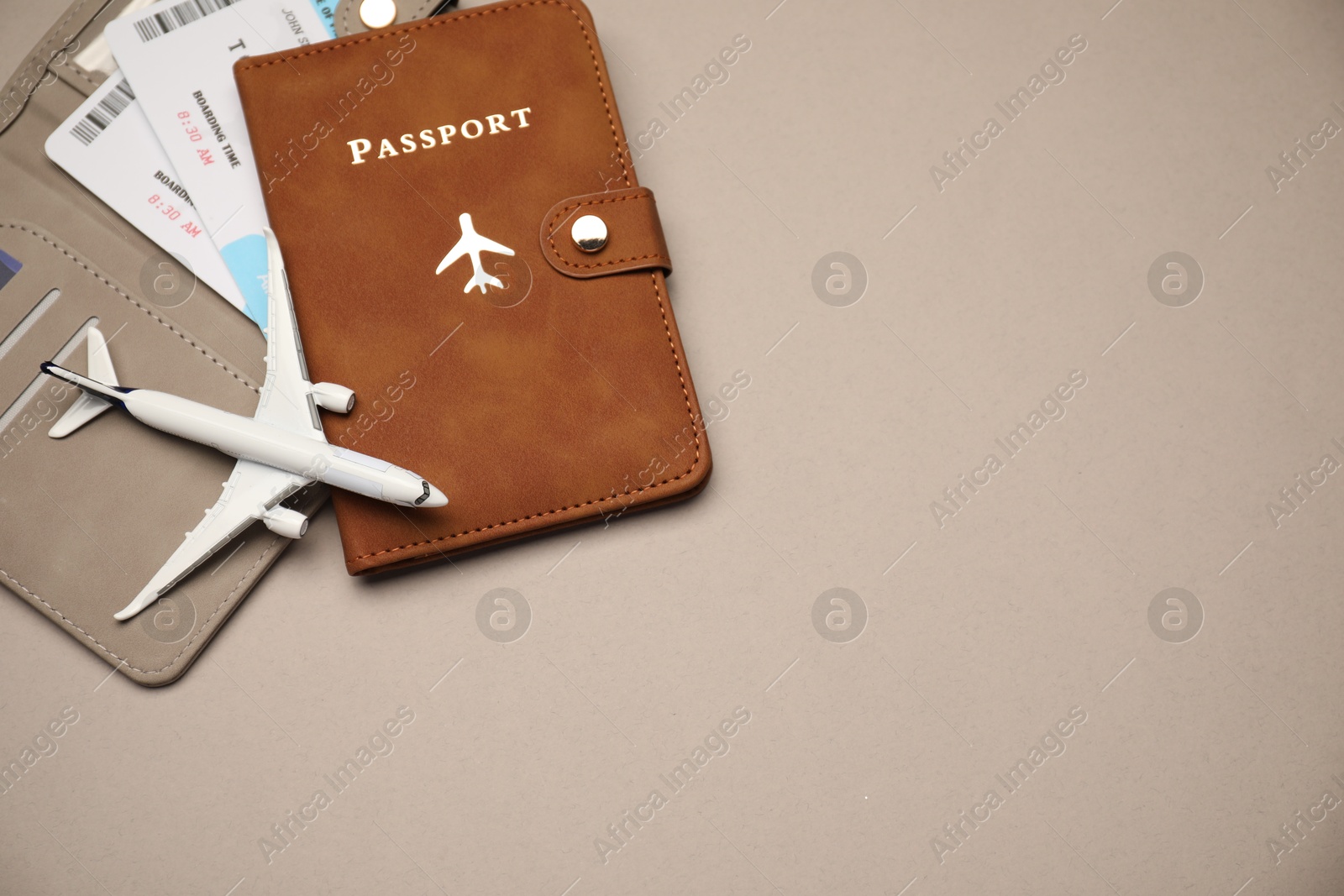 Photo of Airplane model, passport, flight tickets and credit card on beige background, top view. Space for text