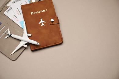 Photo of Airplane model, passport, flight tickets and credit card on beige background, top view. Space for text