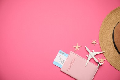 Photo of Airplane model, passport, flight ticket, starfishes and hat on pink background, flat lay. Space for text