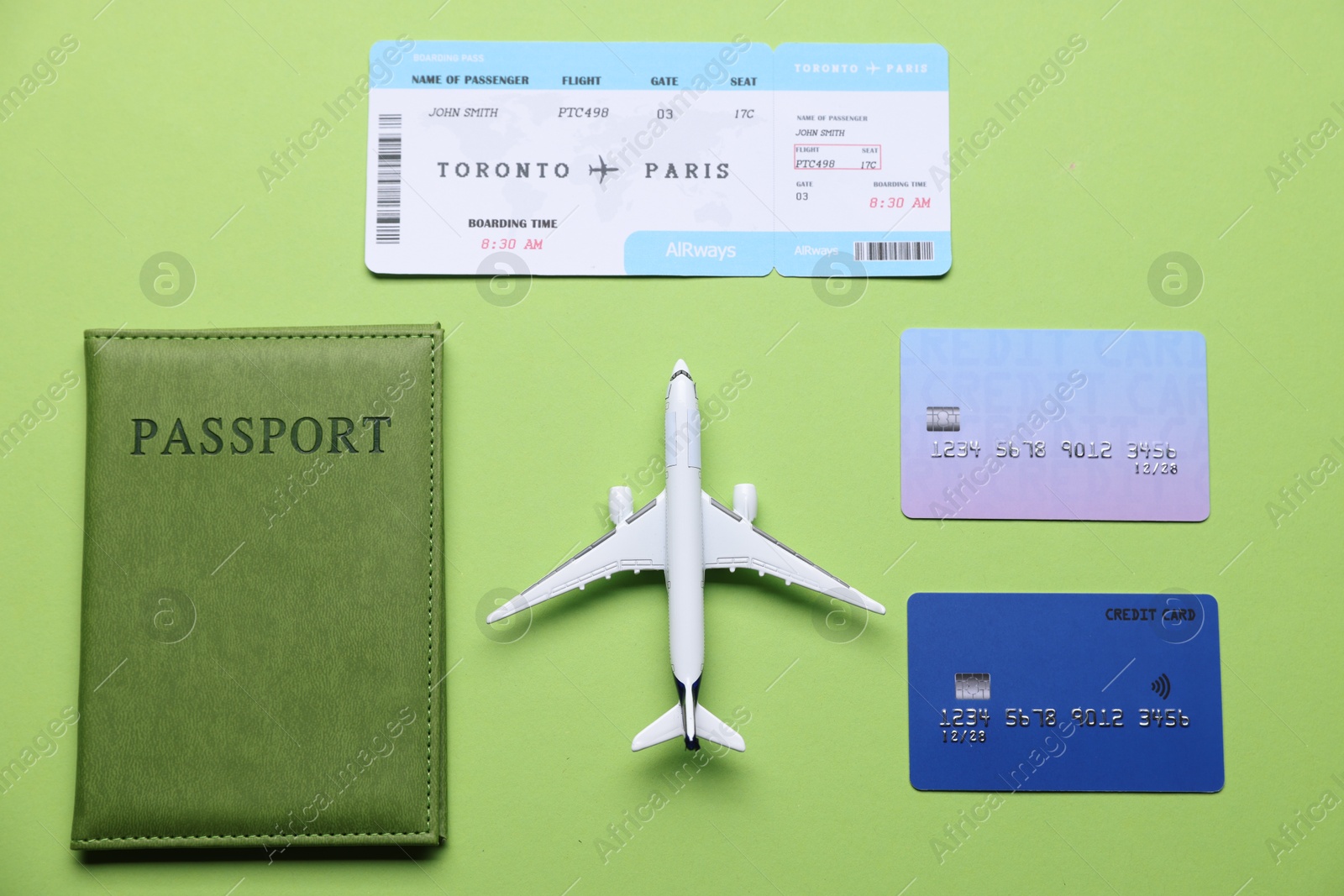 Airplane model, flight ticket, passport and credit cards on green background, flat lay Photo of Airplane model, flight ticket, passport and credit cards on green background, flat lay