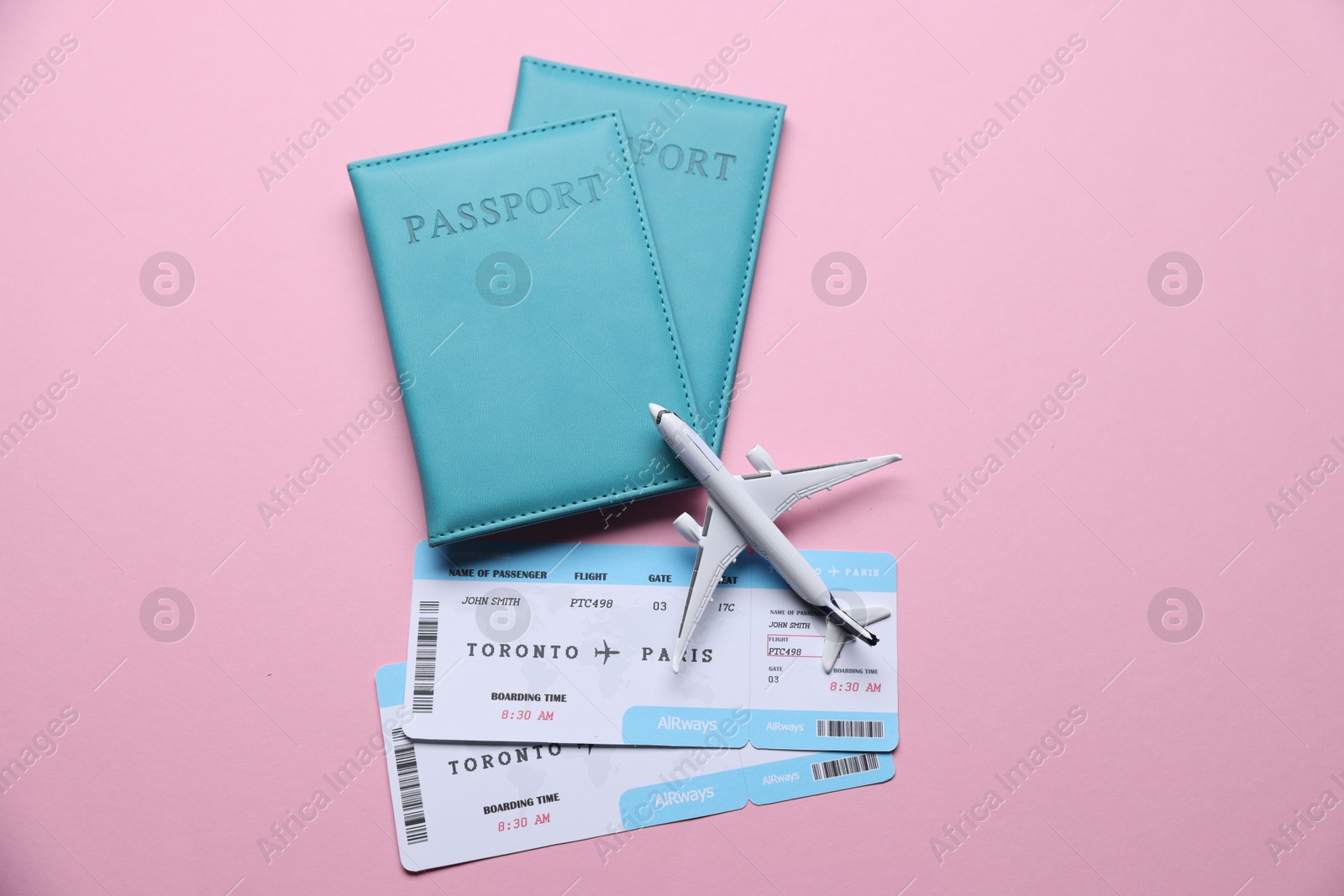 Airplane model, flight tickets and passports on pink background, flat lay Photo of Airplane model, flight tickets and passports on pink background, flat lay