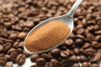 Photo of Spoon with instant coffee powder and beans, closeup