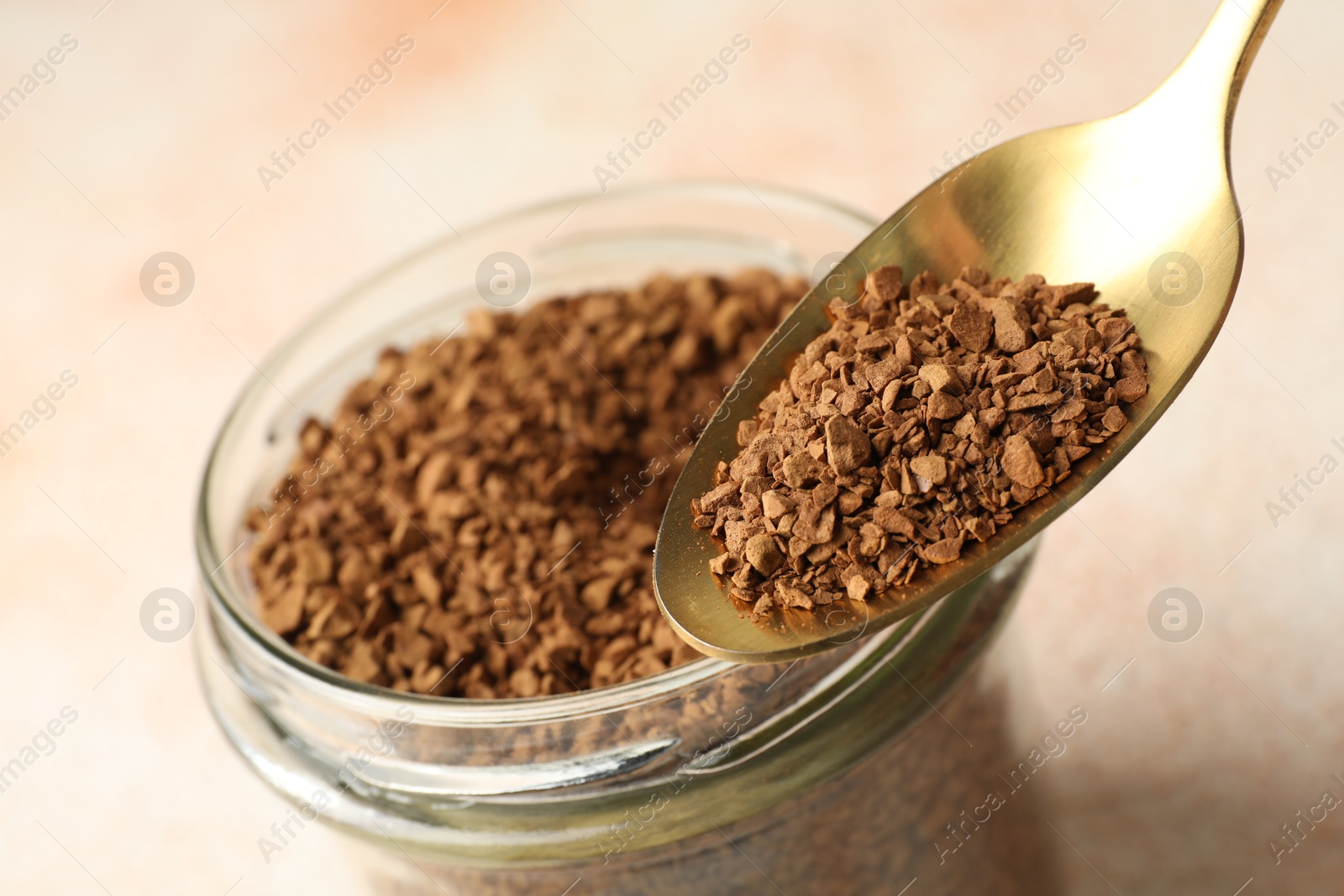 Spoon with granulated instant coffee and jar on light table, closeup Photo of Spoon with granulated instant coffee and jar on light table, closeup