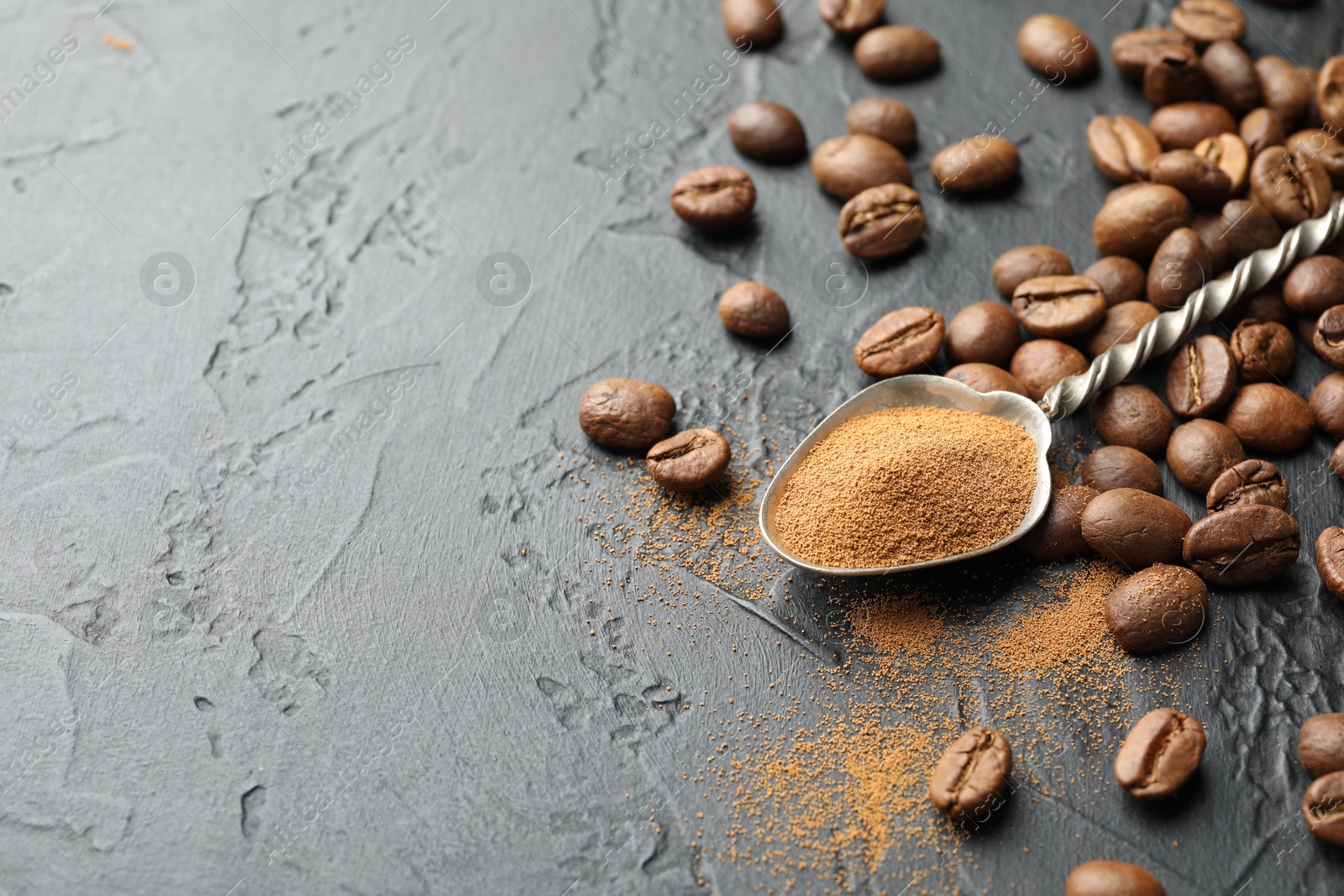 Spoon with instant coffee powder and beans on dark textured table, closeup. Space for text Photo of Spoon with instant coffee powder and beans on dark textured table, closeup. Space for text