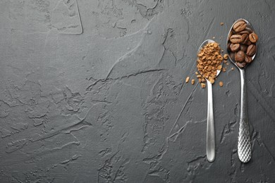 Photo of Spoons with granulated instant coffee and beans on dark textured table, flat lay. Space for text