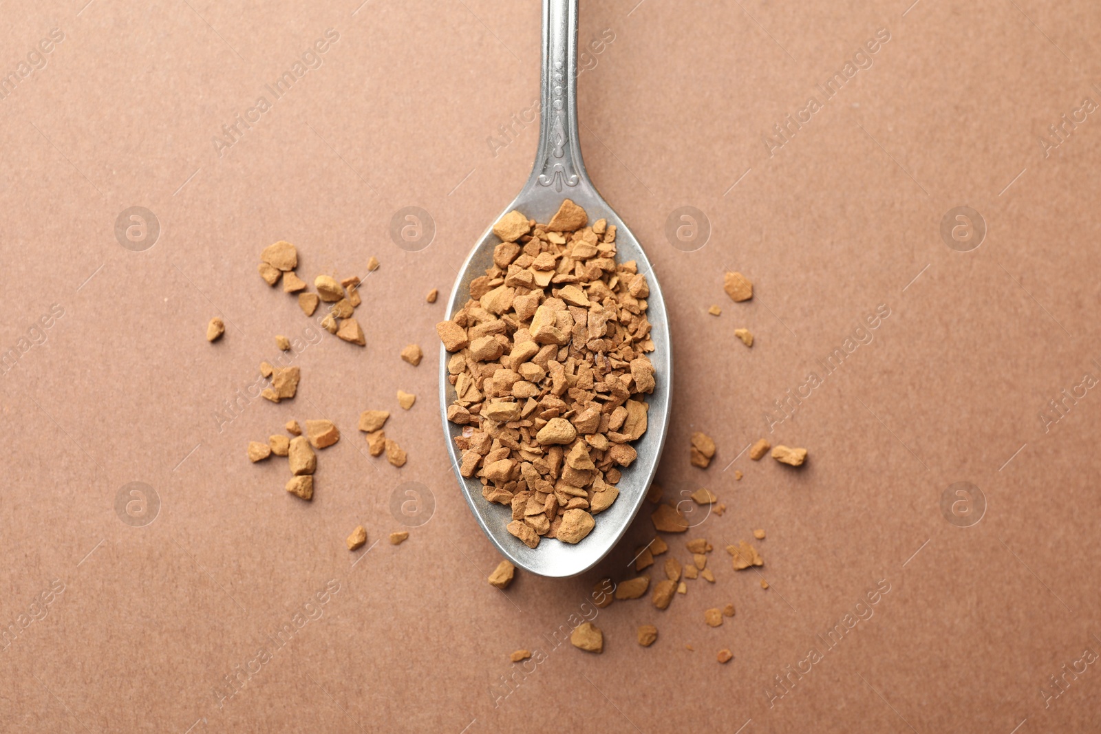 Spoon with granulated instant coffee on beige background, top view Photo of Spoon with granulated instant coffee on beige background, top view