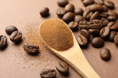 Photo of Spoon with instant coffee powder and beans on beige background, closeup