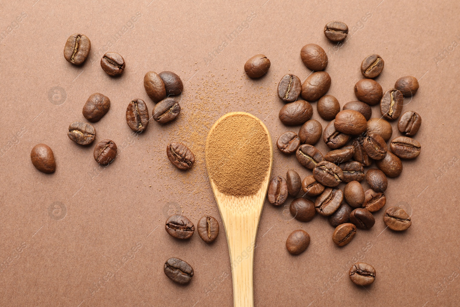 Spoon with instant coffee powder and beans on beige background, flat lay Photo of Spoon with instant coffee powder and beans on beige background, flat lay